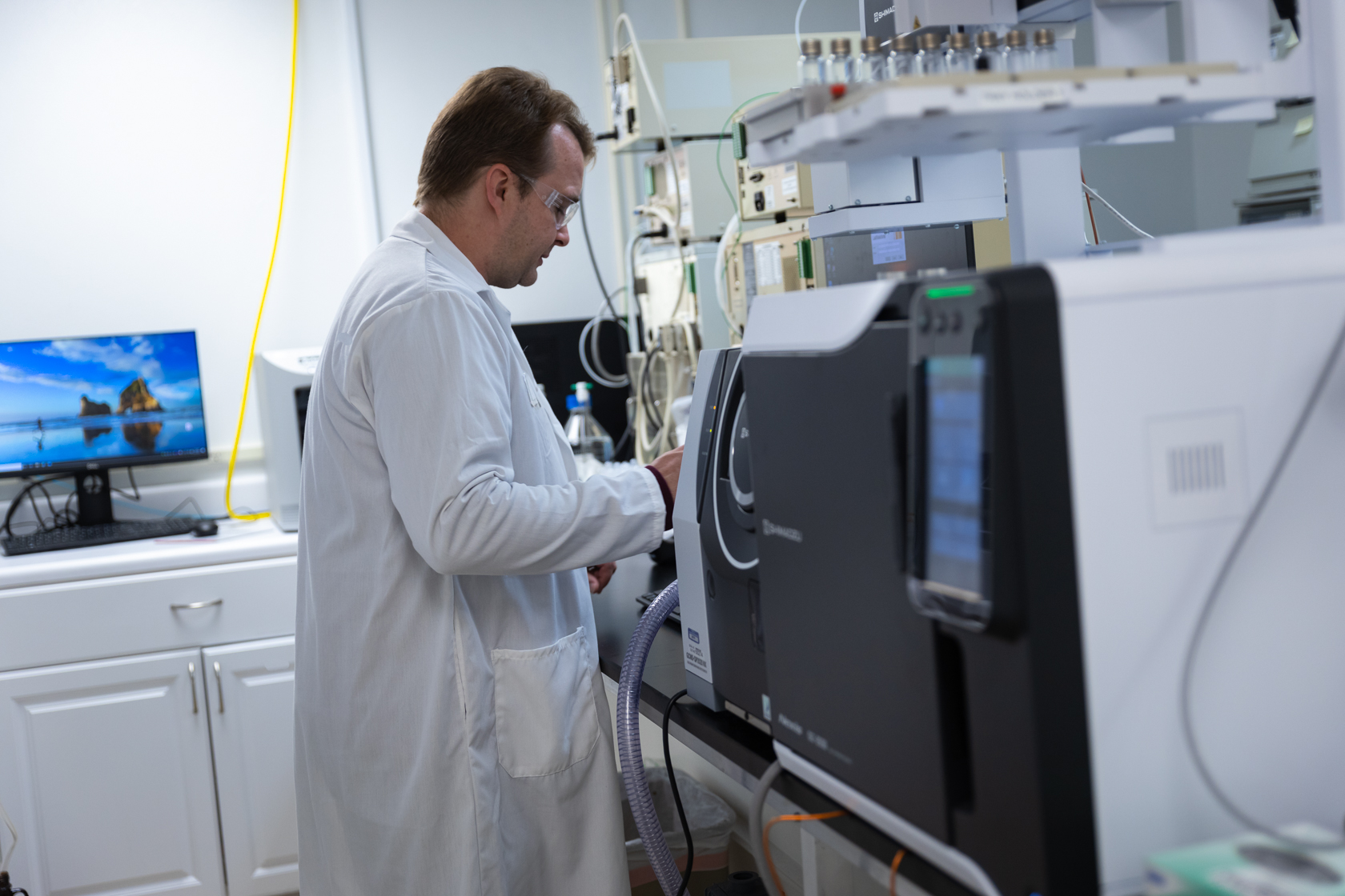 man working in lab coat working on computer