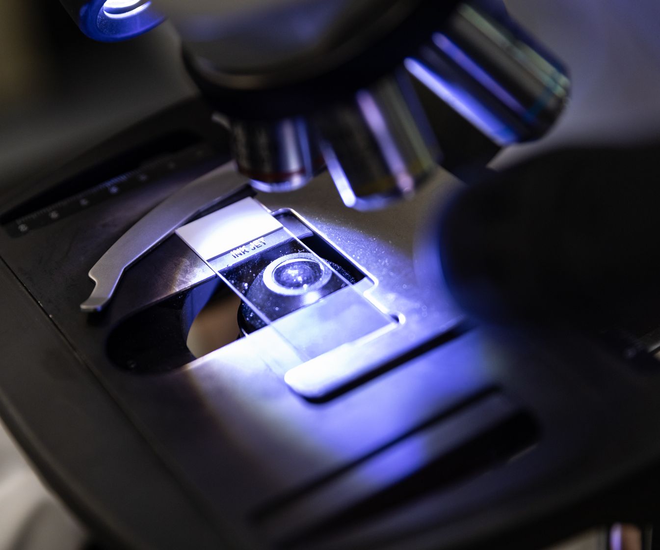 microscope shining blue light on sample